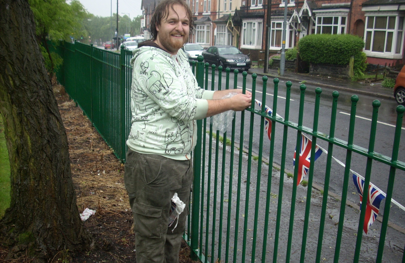 A wet Cllr Robert Alden putting up bunting before the event