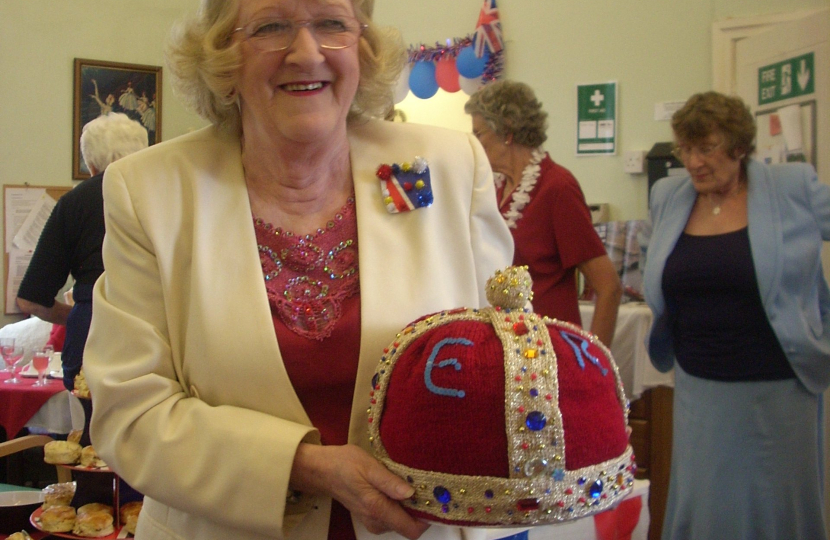 Local resident Wendy Bevan proudly holding the knitted crown she made